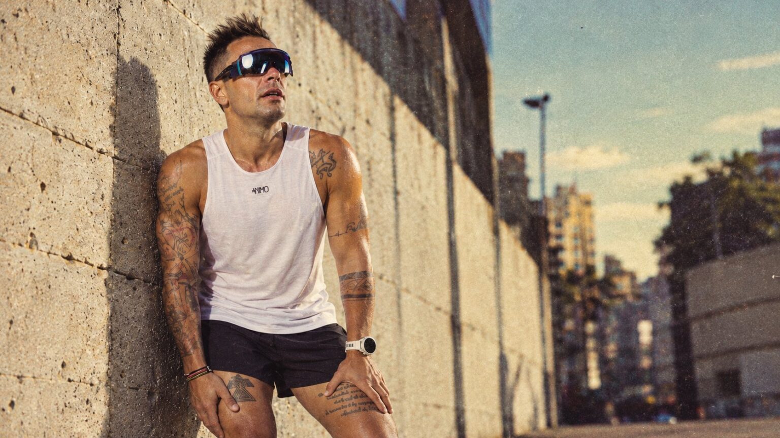 Runner ANIMO in pausa appoggiato a un muro